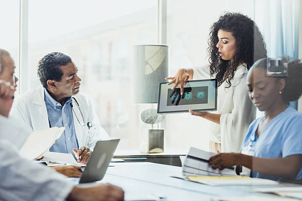 Medical team reviewing diagnostic images during a meeting, discussing patient-focused cancer care in Ocho Rios.